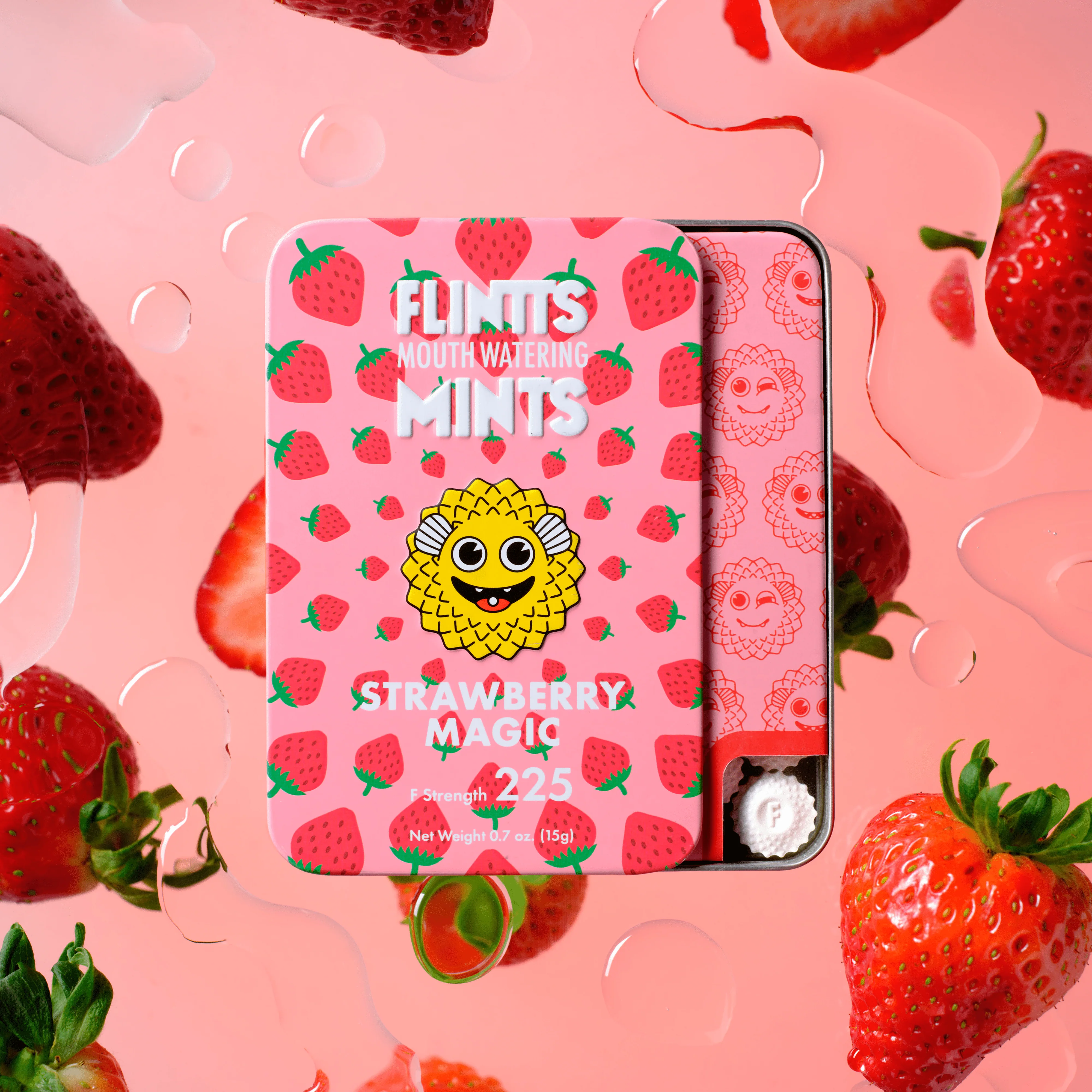 Open tin of Flintts Strawberry Magic mints surrounded by fresh strawberries